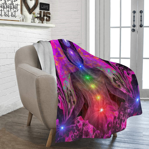 Colorful abstract design blanket draped over a chair in a room with a window and white brick wall.