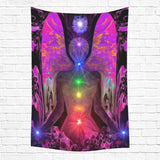 Large wall tapestry of a fuchsia angel with seven chakras through the center of her body hanging on a white brick wall