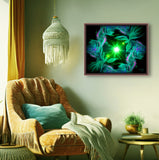 Abstract art in green with two angels facing a central green starburst and surrounded by abstract patterns and displayed on wall by a chair