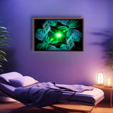 Abstract art in green with two angels facing a central green starburst and surrounded by abstract patterns and displayed in a frame over a massage therapy table