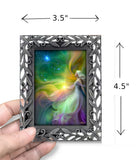 Rainbow goddess mini artwork called Aphrodite by Primal Painter in a decorative pewter frame. In a hand with dimensions. 