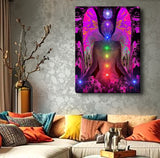 colorful chakra art canvas print with a fuchsia angel torso with the seven chakra colors aligned down the center, and blue lights in her hands and a Reiki symbol over her head displayed over a couch with pillows
