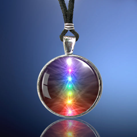round silver necklace featuring a chakra art print with the seven chakras in a vertical line and sealed under a glass dome