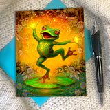 Greeting card of a colorful dancing happy frog on a lily pad with a pen and blue envelope - illustration by Primal Painter. 