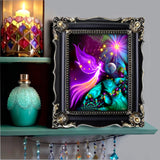 pink guardian angel art with a rainbow starburst and overlooking a green planet, energy art for energy workers and spiritual seekers by Primal Painter in a frame on a bohemian shelf