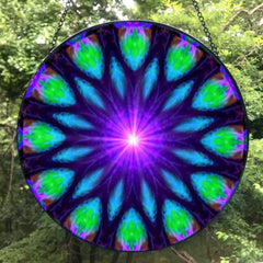 Sacred geometry mandala glass suncatcher in blue, purple, and green with a purple starburst in the center and 12 sections. Artwork called Embrace Light by Primal Painter