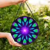 Sacred geometry mandala glass suncatcher in blue, purple, and green with a purple starburst in the center and 12 sections. Artwork called Embrace Light by Primal Painter
