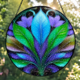 Back view of a Textured glass suncatcher of a blue, green, and purple botanical leaf design. 