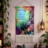 A bohemian-style wall tapestry hanging on a beige wall, decorated with a colorful illustration of Flower Child by Primal Painter, surrounded by flowers and The Reiki Principles The tapestry features a wooden hanging rod, a natural twine hanger, and a white macrame fringe at the bottom.