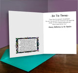 Open card with text and decorative border on a wooden surface with a purple background