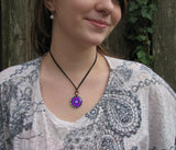 Intuition mandala necklace in a round copper setting. Purple and blue theme. Displayed on a model