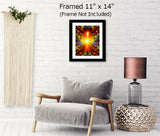 Orange and red abstract angel artwork with a starburst center, rainbow colors in the wings, a heart at the bottom, and tiny figures around the border and presented in a frame hanging over a chair