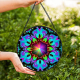 Textured glass mandala suncatcher featuring rainbow artwork called Flowering Lotus by Primal Painter. 
