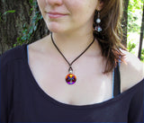 Phoenix Rising wearable art necklace in a round silver setting worn on a model