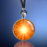 Handmade chakra necklace featuring a bright orange starburst art print representing the sacral chakra and sealed under a glass dome