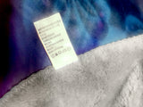 Close-up of a label on a textured fabric with a blue and purple gradient background.