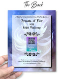 The back of a Greeting card by Primal Painter featuring a blue, violet, and white fairy with white flowing hair, floating in the clouds called Sylph Windsong. 