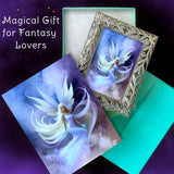 Framed artwork of a dreamy fairy in the clouds with white hair and wings, along with a matching story greeting card by Primal Painter. 