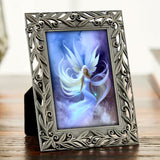 Framed artwork of a dreamy fairy in the clouds with white hair and wings by Primal Painter. 