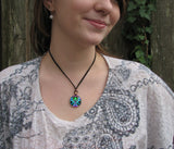 Twin flame necklace called Unconditional Love in a round copper setting and set under a glass dome. shown on a model