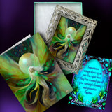 A fantasy art print and matching decorative card set displayed on a dark purple background. The set includes a print with a silver ornate frame showing a glowing fairy with green and gold wings, a matching story card, and a blue decorative card with inspirational text and the name 'Primal Painter'.