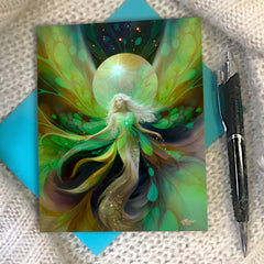 An illustrated story card featuring a fantasy fairy illustration in vibrant shades of green, yellow, teal, and dark navy, styled on a textured white knit blanket next to a black pen and a turquoise envelope. Art by Primal Painter.