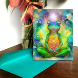 Colorful greeting card with a frog  in a meditation pose and surrounded by flowers. Illustration by Primal Painter.