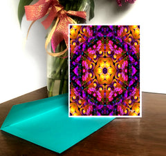 A colorful mandala-patterned greeting card with a white border, displayed on a table with a decorative background by Primal Painter.
