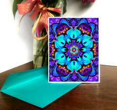 A greeting card with a colorful kaleidoscope-like floral pattern, predominantly in shades of blue and purple, with a white border and a blank interior for a personal message by Primal painter.