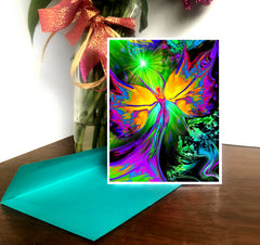 A colorful artistic greeting card with a design of a chakra angel, featuring a rainbow-colored aura and wings, displayed on a table with a decorative background. Art by Primal painter