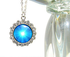 Blue starburst art under glass in a silver necklace setting by Primal Painter
