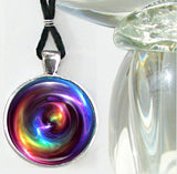 Handmade round necklace featuring original arty by Primal Painter with rainbow chakra colors in a swirling pattern and sealed under a glass dome
