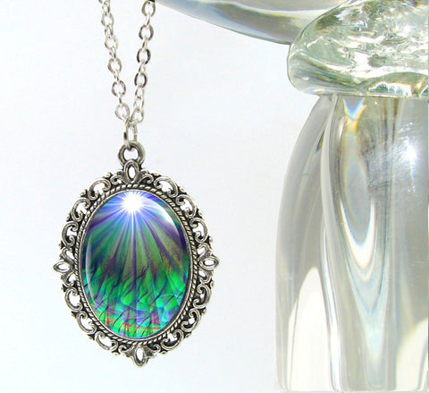 oval victorian style necklace featuring metaphysical art of green heart chakra rays under a white starburst