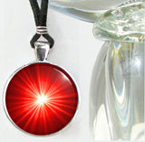 Handmade first chakra necklace featuring a bright starburst art print sealed under glass and representing the root chakra