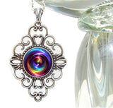 lacy filligree necklace featuring a rainbow chakra swirl print sealed under a glass dome