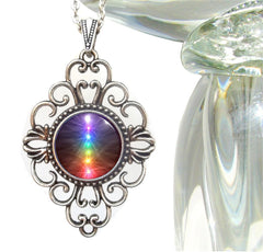 A chakra necklace with a colorful iridescent pendant featuring a geometric pattern, attached to a silver-colored chain. by Primal Painter