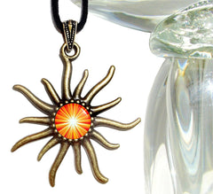 orange starburst second chakra artwork under glass in a sun shaped pendant by Primal Painter
