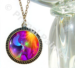 A colorful abstract angel necklace with a rainbow-colored print on a round pendant, attached to a bronze-finished chain by Primal Painter.