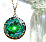 large bronze necklace with a twin flames angel art print in green heart chakra colors and sealed under glass