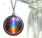 chakra art necklace in a bronze setting with the seven rainbow chakras aligned in a straight line