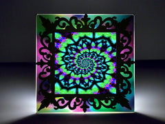 A colorful 3D framed art nightlight with a spiral design, encased in a clear acrylic frame, intended as a decorative lighting accessory. Art by Primal Painter