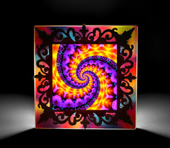 A multicolored, psychedelic night light depicting a spiral pattern, encased in a Victorian-style wooden frame. Art by Primal Painter