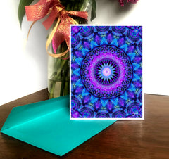 A greeting card with a geometric mandala design in purple and blue shades, displayed with a blue envelope by Primal Painter.