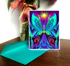 A vibrantly colored chakra art notecard featuring a stylized butterfly fairy with intricate, rainbow-colored patterns by Primal Painter. The card is accompanied by a brightly colored envelope.