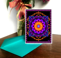 A greeting card with a geometric mandala design in multiple colors accompanied by a brightly colored envelope. Art by Primal Painter